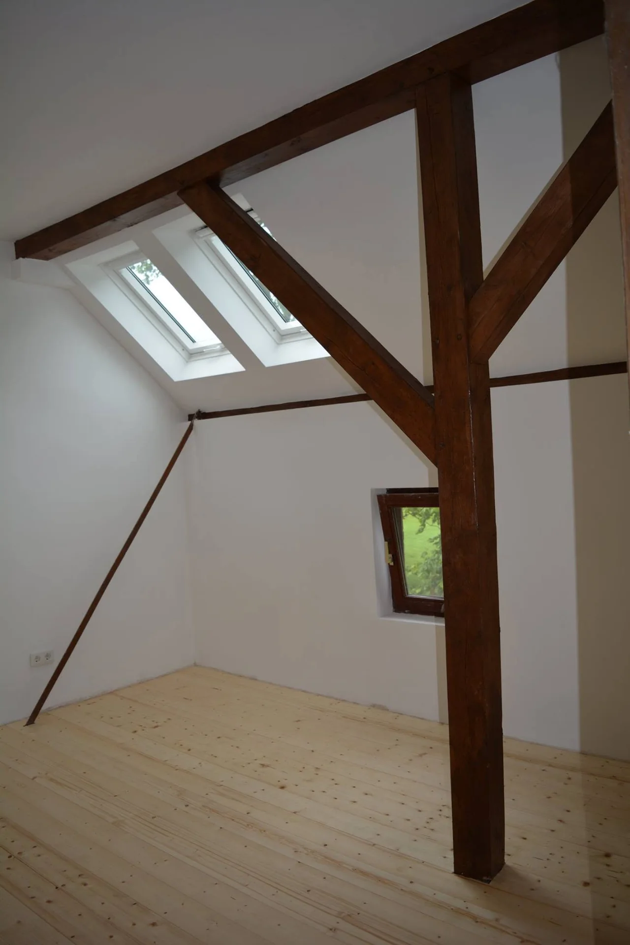 Ausgebautes Dachgeschoss mit Holzfußboden und weißen Wänden